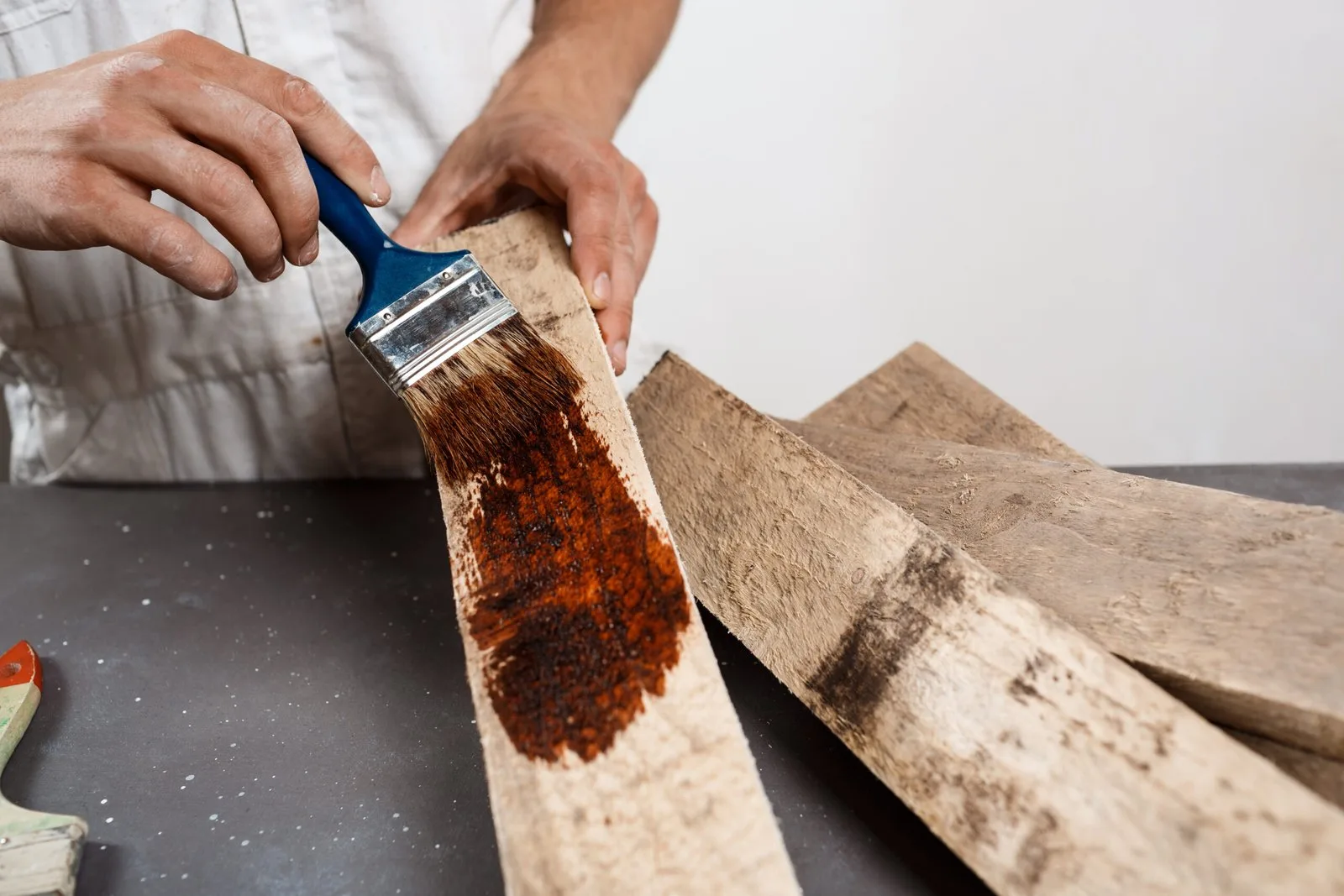 Aplicando tinte a tablas de madera con brocha